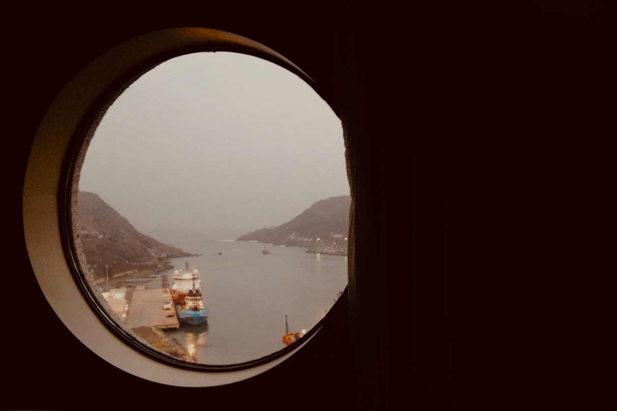 a view of a body of water through a round window.
