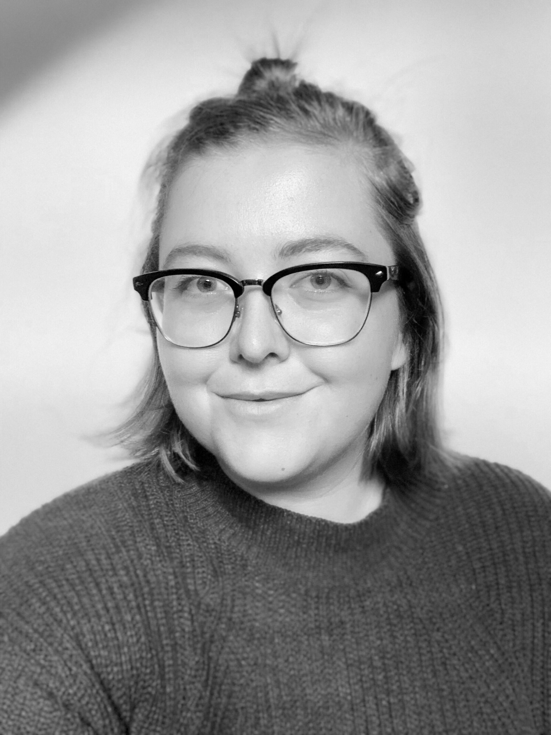 A black and white photo of a woman wearing glasses.